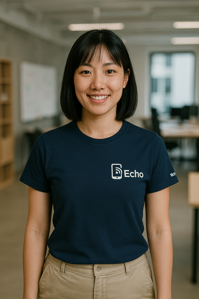 東亞女性穿著深藍色 Echo 制服，站在辦公空間中微笑看鏡頭，呈現品牌一致形象與科技團隊的專業穿搭。